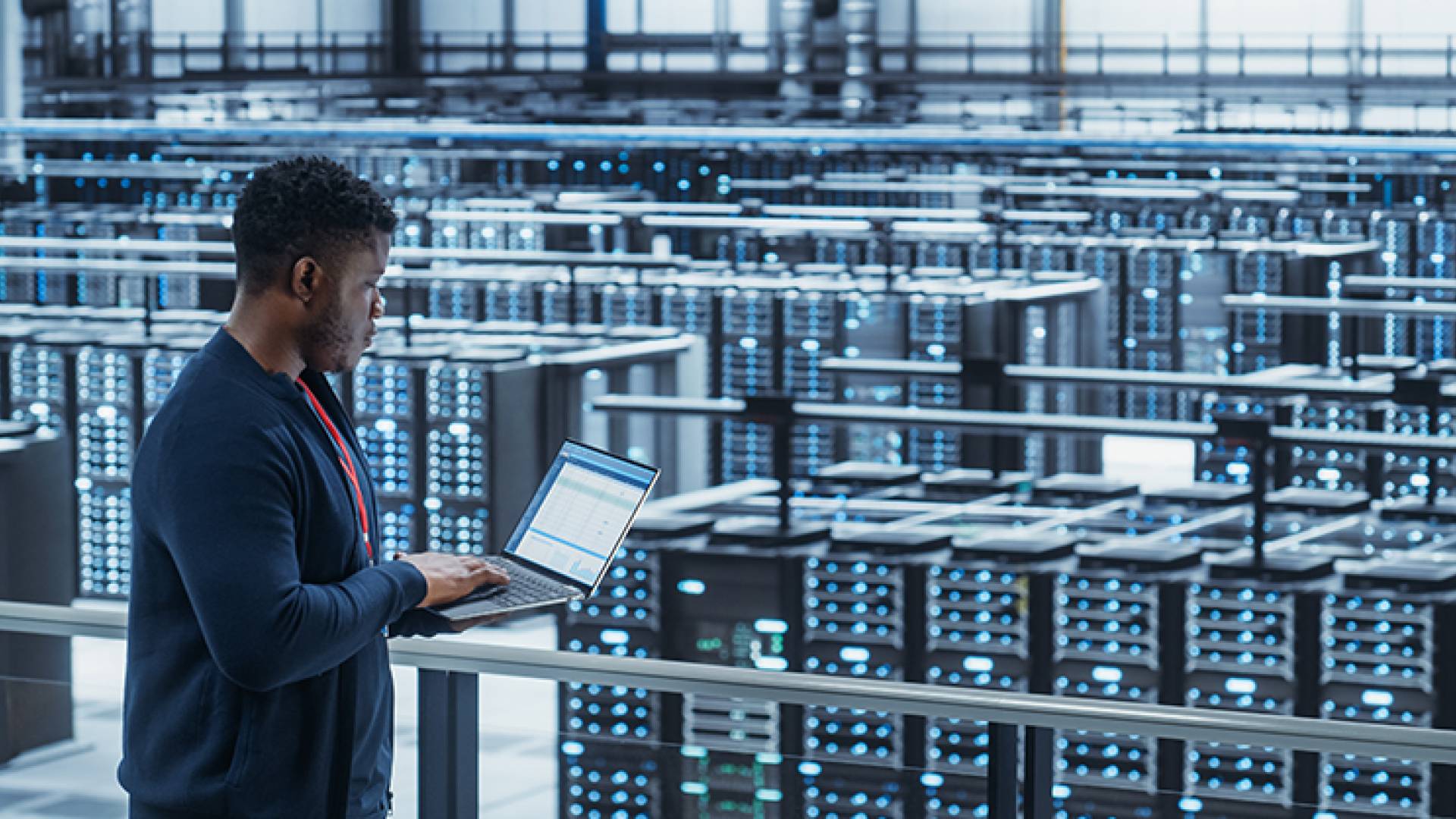 Data engineer using a laptop computer in a cloud computing facility.