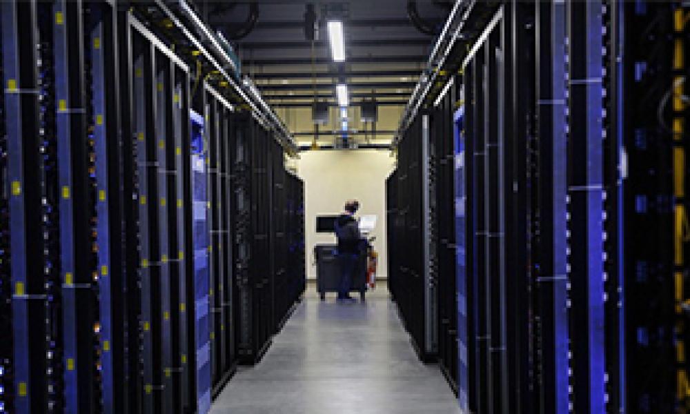 A man making configurations inside a data server room.