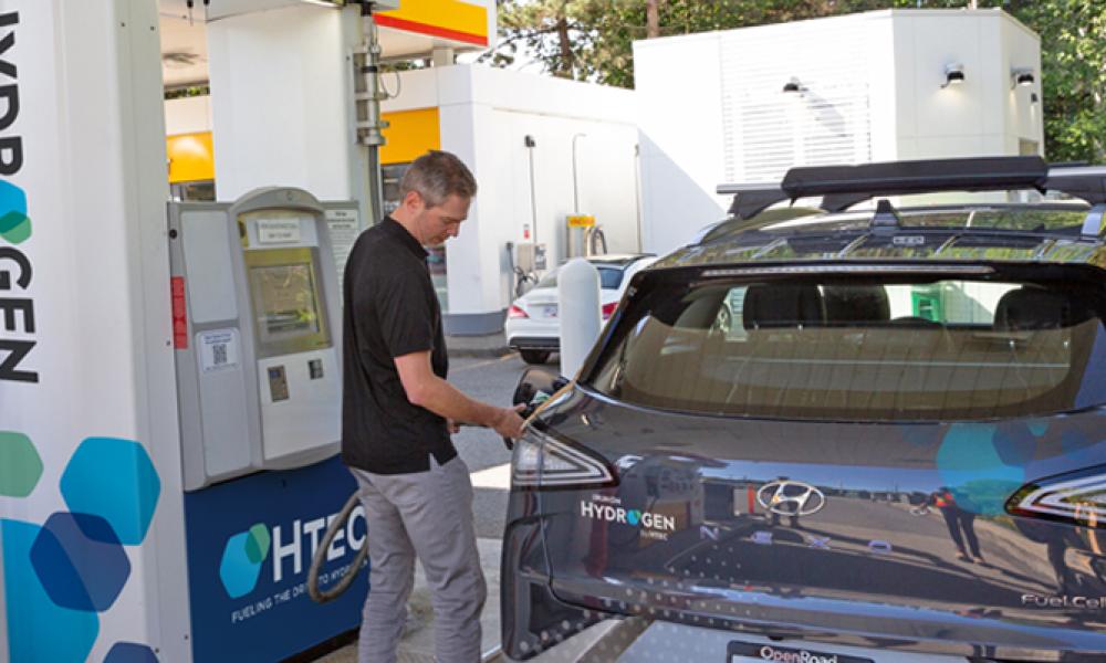 A man filling a Hyundai Nexo at a hydrogen station.